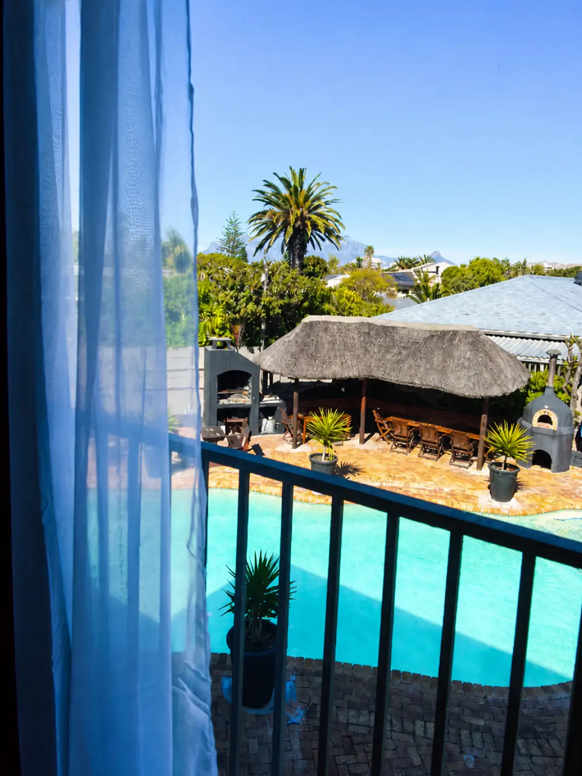Pool and thatched terrace seen through the hotel window